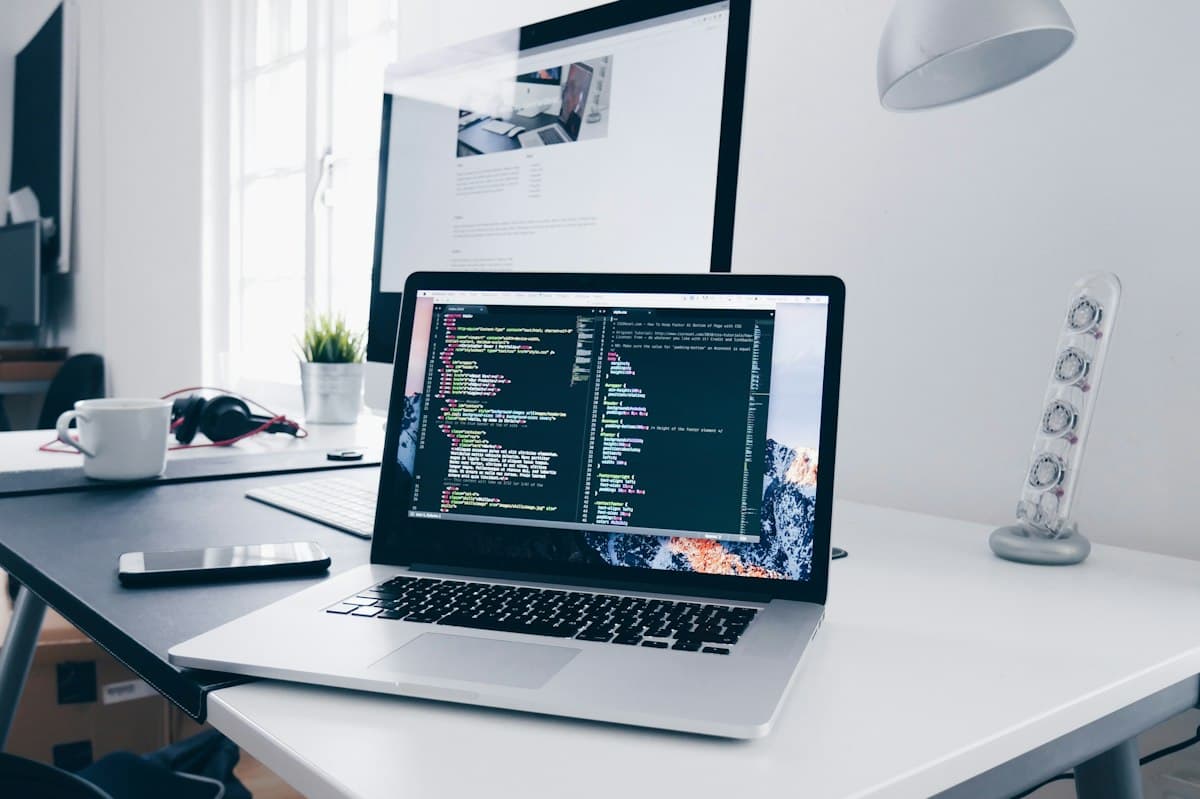 Laptop on a desk showing a code editor