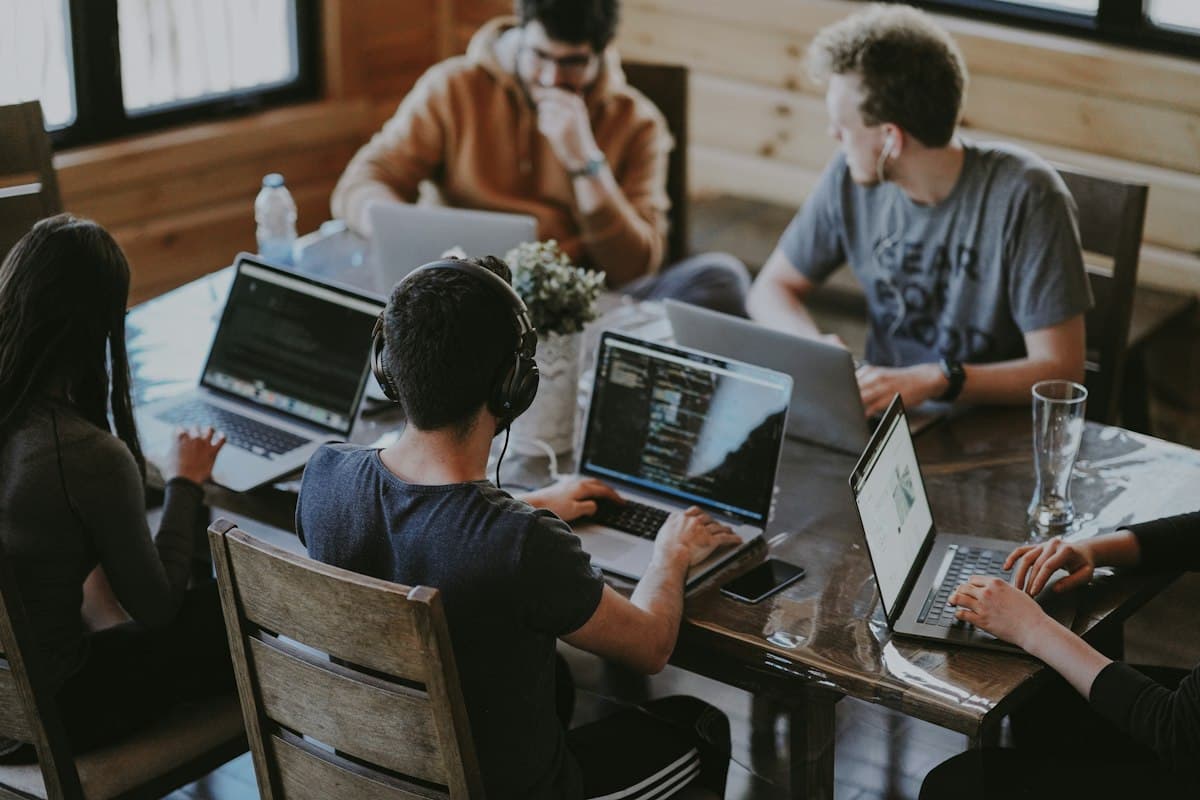A team working on laptops around a shared table